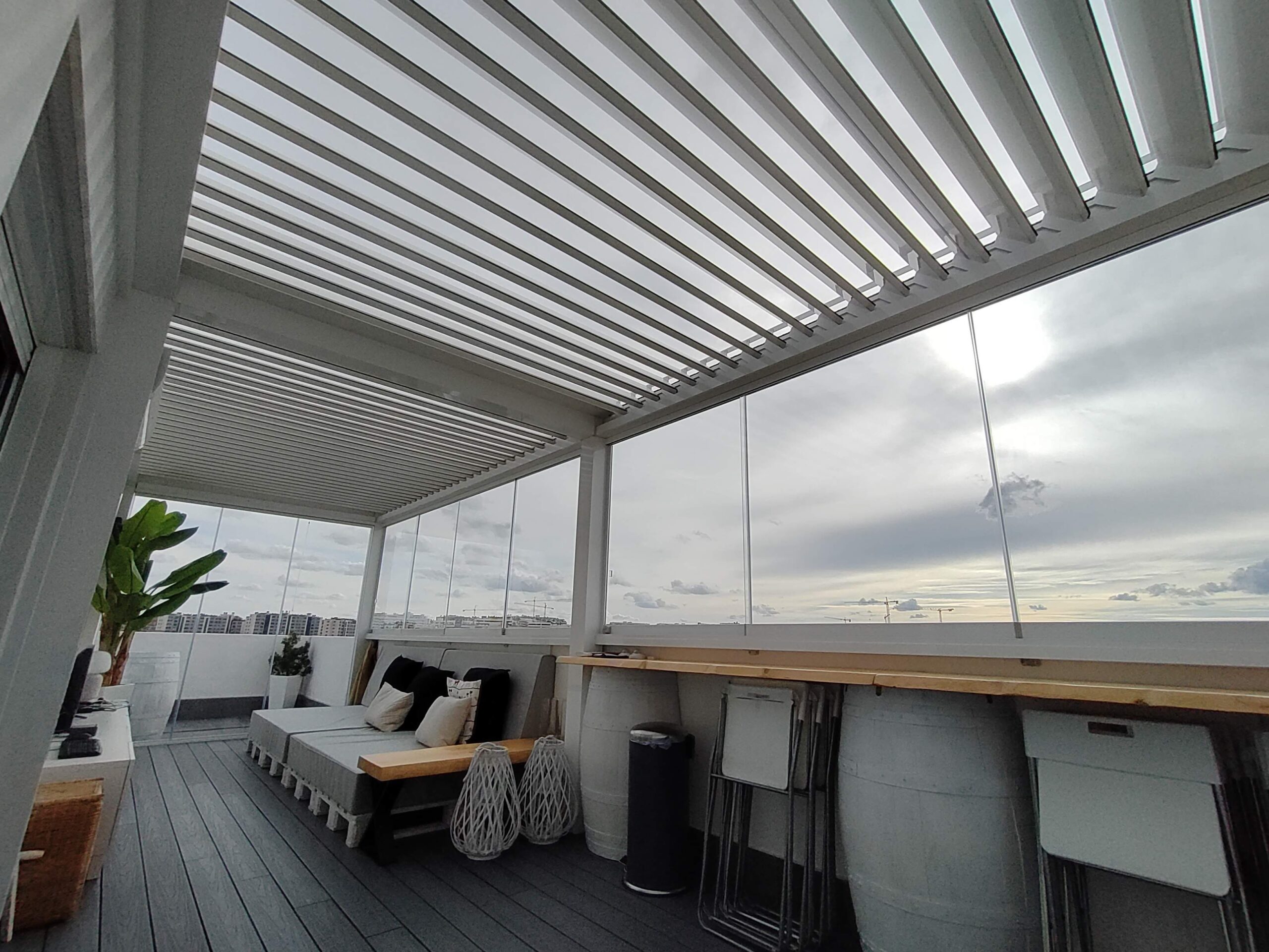 Pérgola bioclimática con cerramiento de cristal en terraza de ático